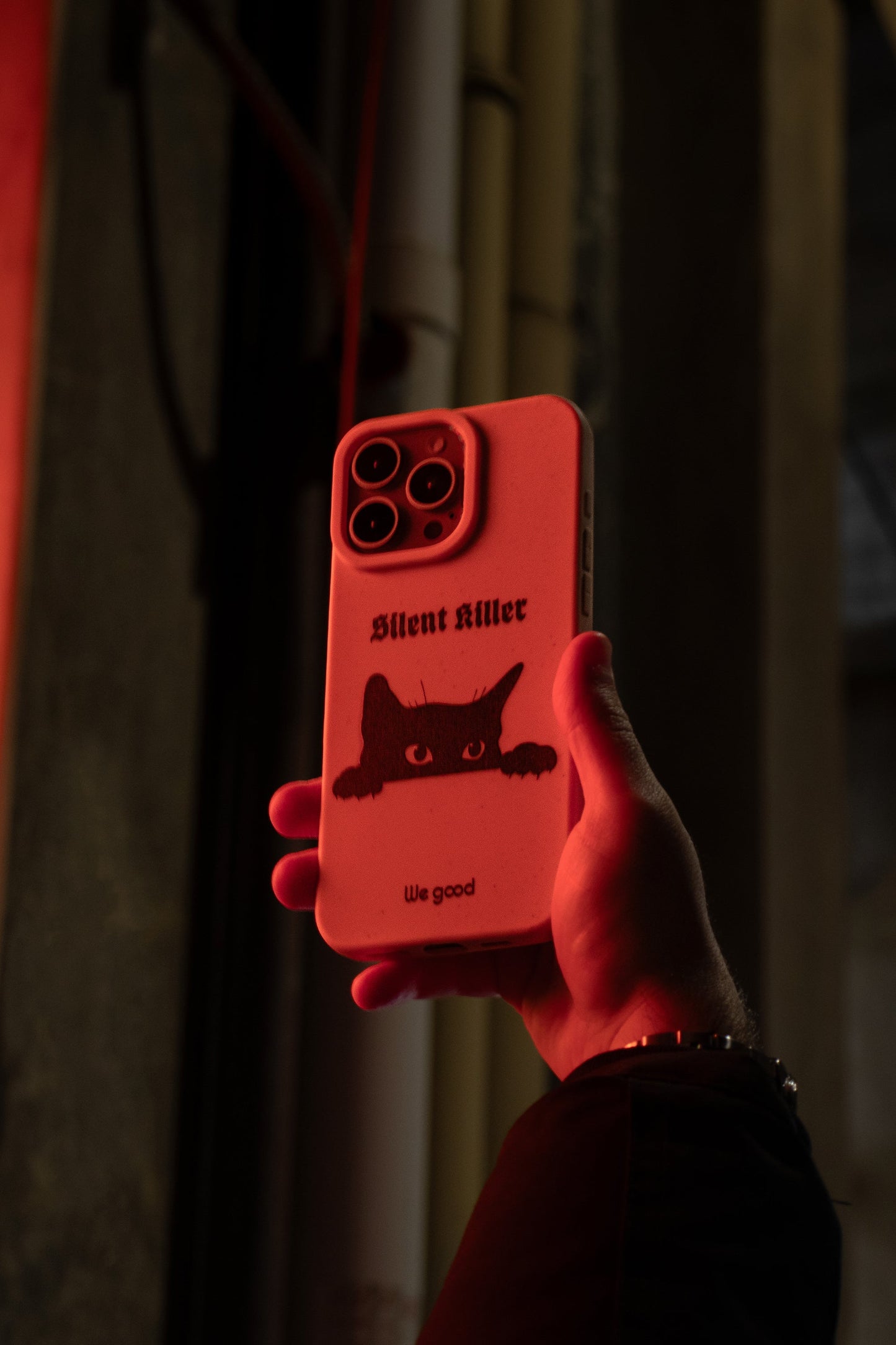 We Good Tpu iPhone case with wheat mix speckled in a flamingo pink color with a black 'silent killer' text in a gothic font and below it a black cats face creeping up and stalking.