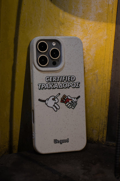We Good Tpu iPhone case with wheat mix speckled in an off-white color with 'certified trakadoros' white and black bold text print and below it two cartoon hands with white gloves with one holding a red pack of cigarettes and the other hand taking one from the pack resting on a yellow phone booth interior stand.